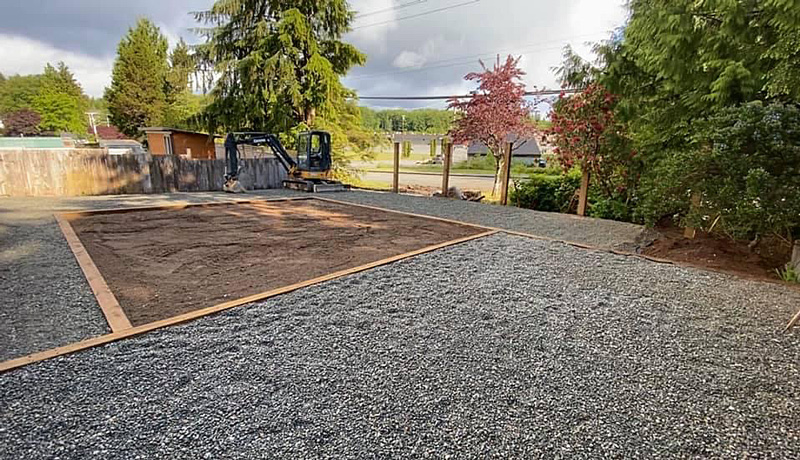Dylan Shaw creating a garden bed and laying gravel in Port Hardy