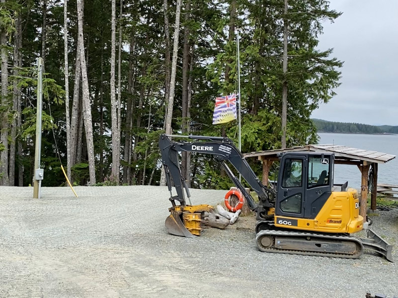 excavator operator installing underground electrical line service in Port Hardy